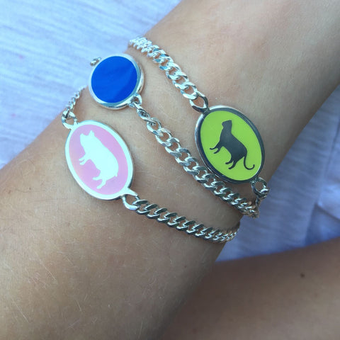 wrist stack of animal id bracelets in multi-colored enamel pink blue and green